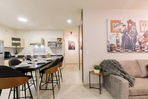 Une cuisine moderne avec un coin repas, un canapé et un tableau au mur.