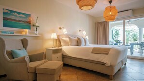 Un dormitorio con cama, una silla, una mesita de noche, una lámpara, un cuadro en la pared y vistas al exterior.