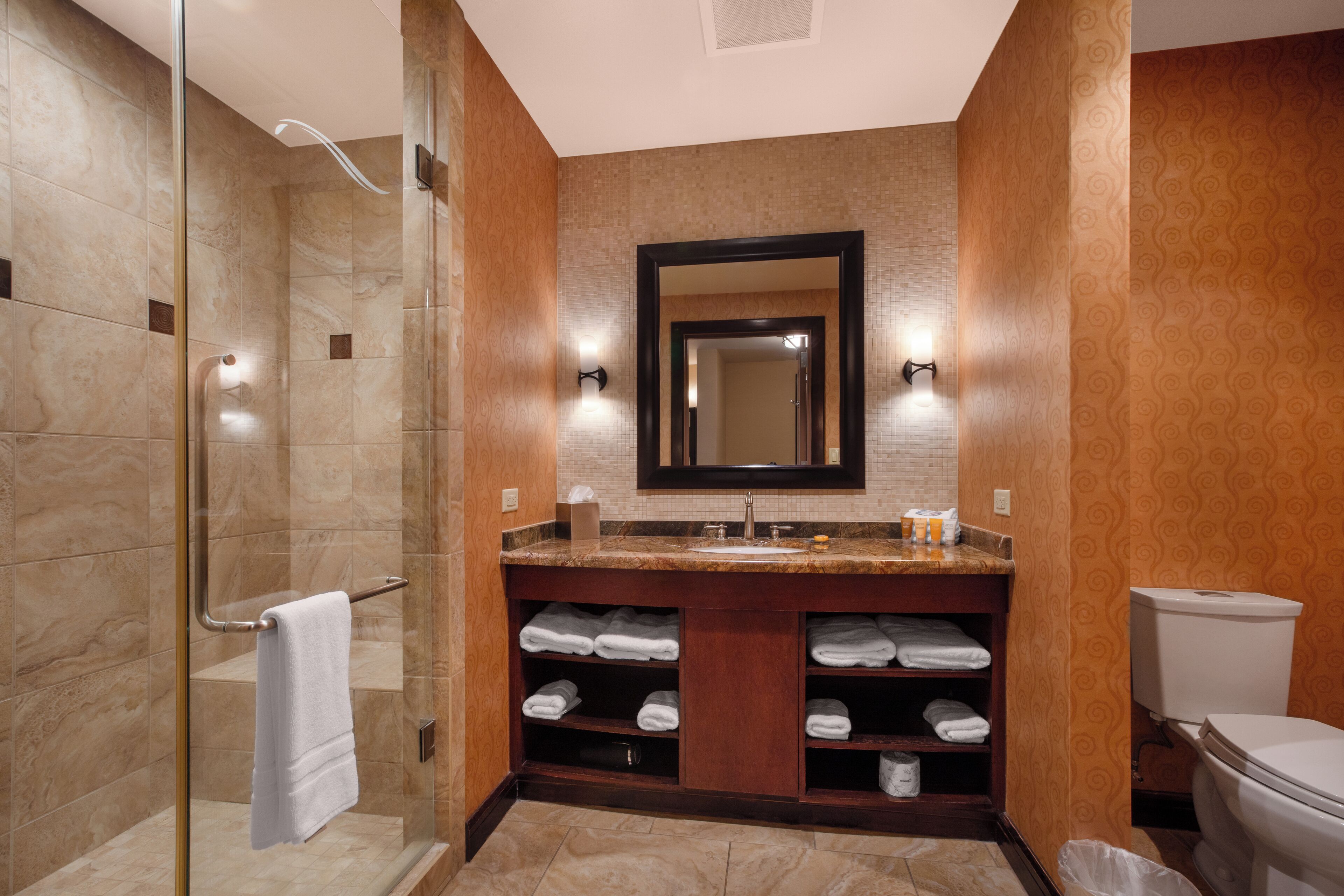 Une salle de bain moderne avec une douche à parois de verre, un meuble-lavabo avec un miroir et des toilettes.