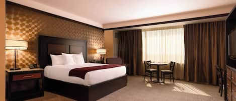 Une chambre d’hôtel avec un grand lit, des tables de chevet, un bureau et une chaise.
