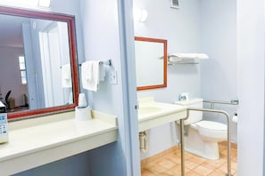 A bathroom with a mirror, sink, toilet, and a towel rack. - Happy Extended stay (Madisonville)