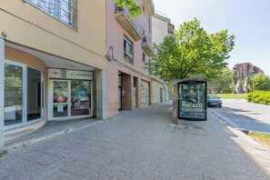 Ein Gebäude mit Schaufenster, einer Schautafel und einem parkenden Auto.