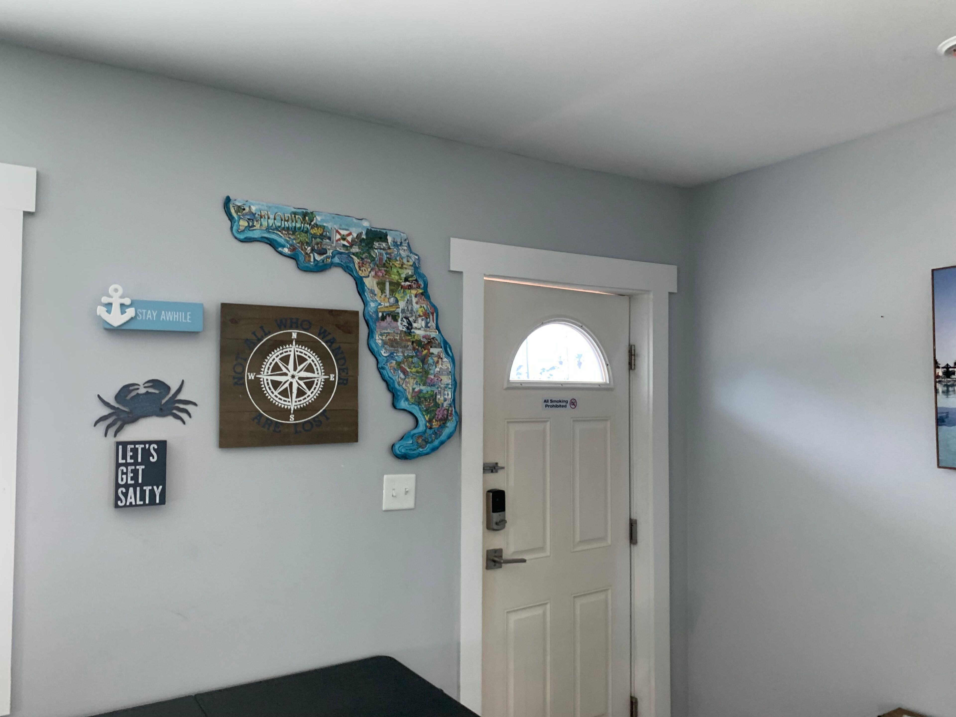 A room with a wall decorated with a Florida map, a compass, and motivational signs.