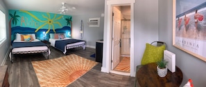 Bedroom with two beds, a painted beach mural, and an en suite bathroom.