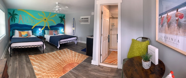 Bedroom with two beds, a painted beach mural, and an en suite bathroom.