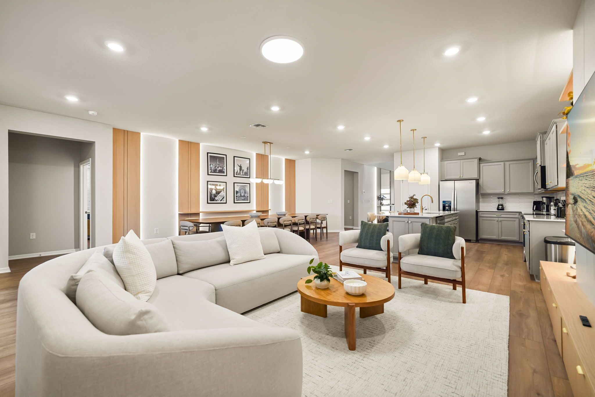 A modern living room with a sectional sofa, a coffee table, and a dining area with chairs.