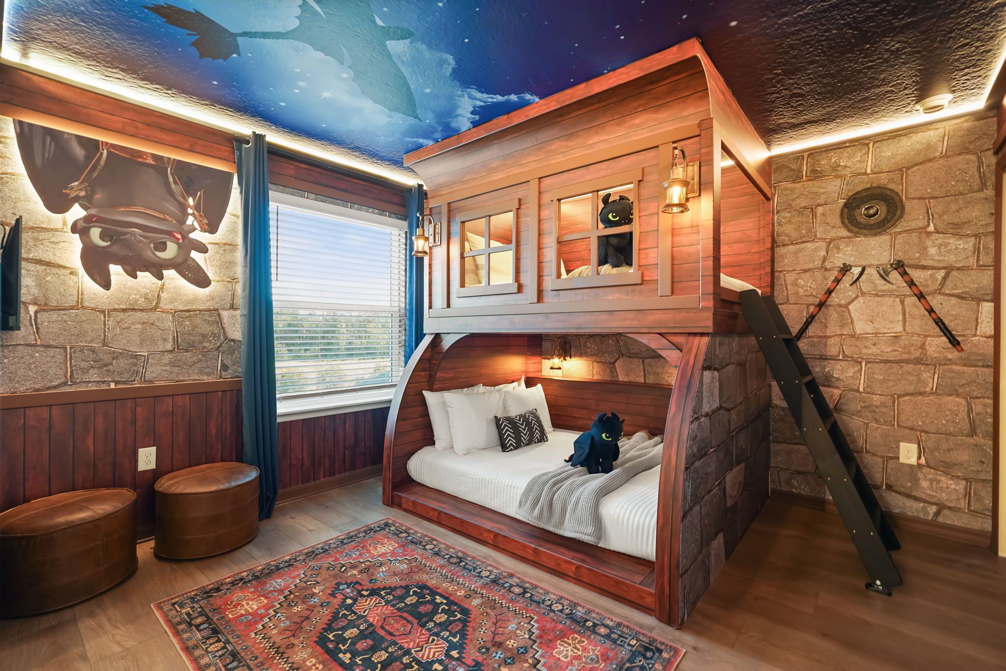 Un dormitorio acogedor con techo inclinado, una cama con almohadas, una alfombra y una pared de piedra.