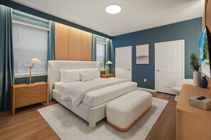 Une chambre à coucher avec un lit, des tables de chevet, un bureau et une chaise.