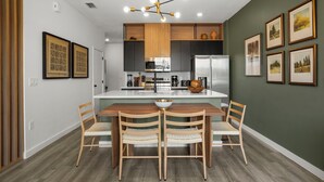 Une cuisine moderne avec un îlot central, des chaises en bois et une table à manger.