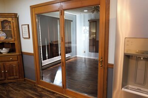 A room with a sliding glass door leading to a balcony, a wooden cabinet, and a stainless steel appliance. - Timeless in Tennessee (Jonesborough)