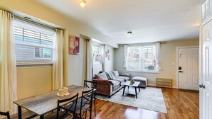 A living room with a wooden dining table, sofa, and a radiator. - 3BR Near Takoma Metro & DC Hospitals (Washington)
