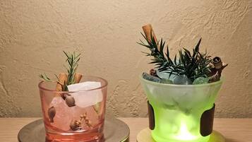 Two candle holders, one with a pink candle and the other with a green candle, both on wooden bases.