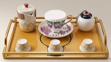 A tray with a teapot, teacup, saucer, and four small cups.