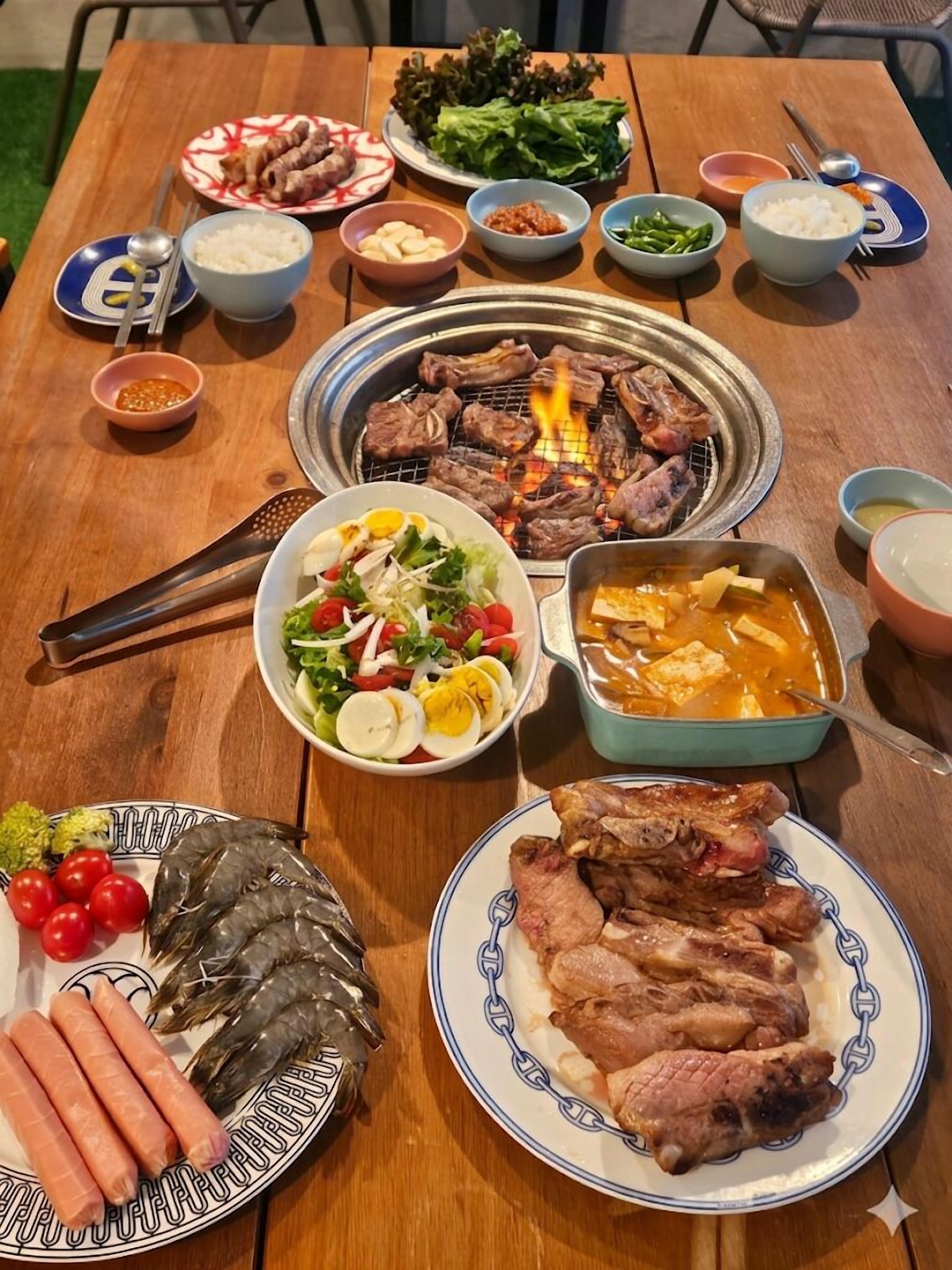 A table with various dishes including grilled meat, salads, and side dishes.