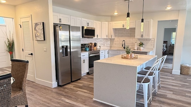 A modern kitchen with white cabinets, stainless steel appliances, and a central island. - Waterfront home with pool, billiards, 4 min beach (Punta Gorda)