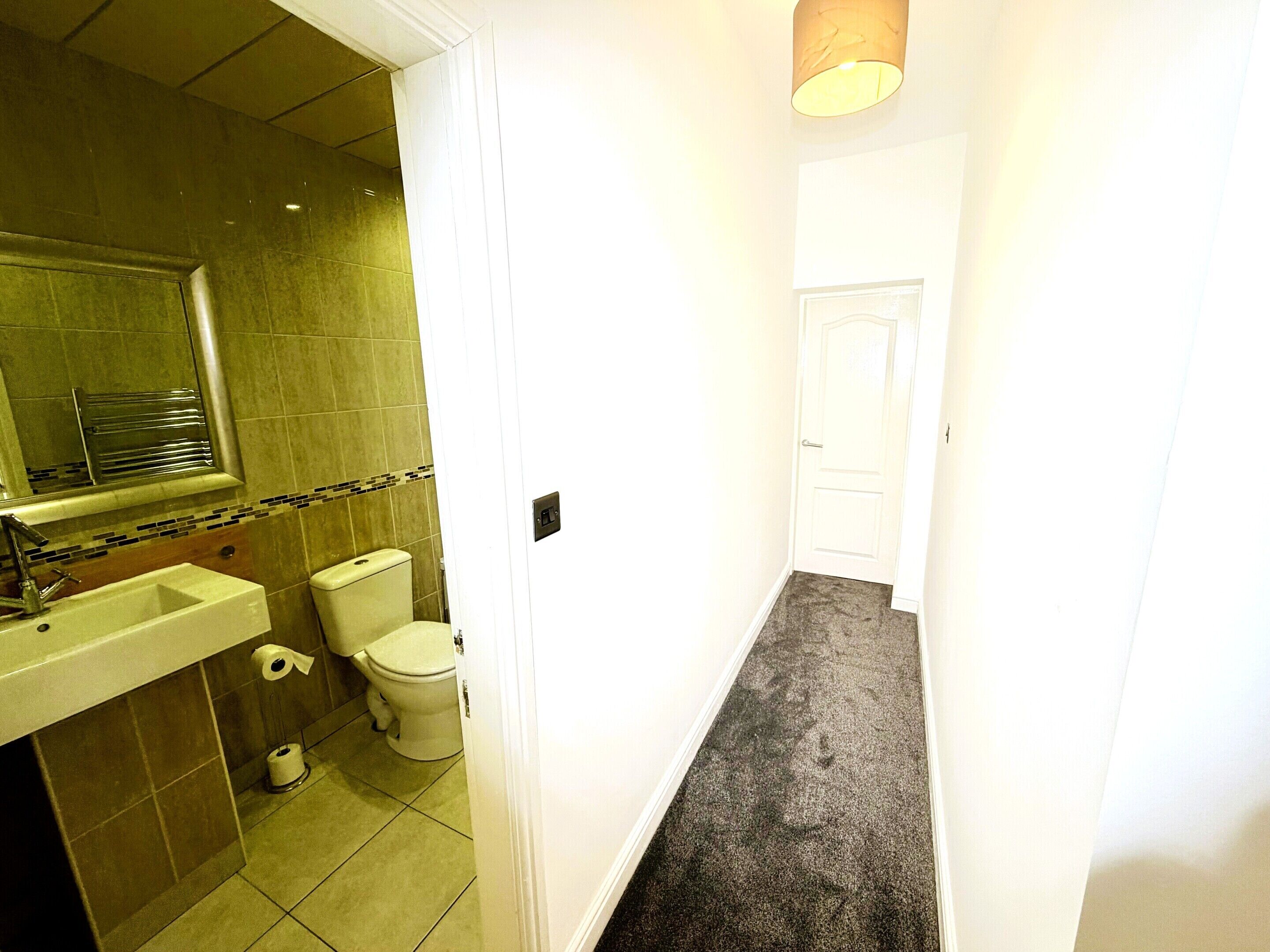 Une salle de bain avec un lavabo, des toilettes et un miroir.