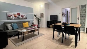 Ein modernes Wohnzimmer mit einer Couch, einem Couchtisch, einem Esstisch und Stühlen.