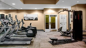 Una palestra con tapis roulant, ellittiche e attrezzature per pesi.