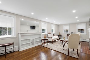 A spacious living room with a fireplace, white built-in shelving, and a large mirror. - NEW Listing Walk to Main Street and Hyannis Harbor (Barnstable)