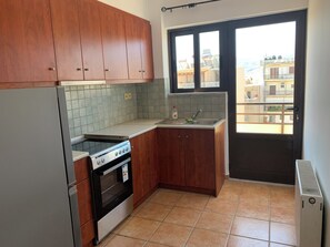 Eine Küche mit Holzausstattung, einem Herd, einem Backofen, einer Spüle und einem Fenster mit Blick auf Gebäude.
