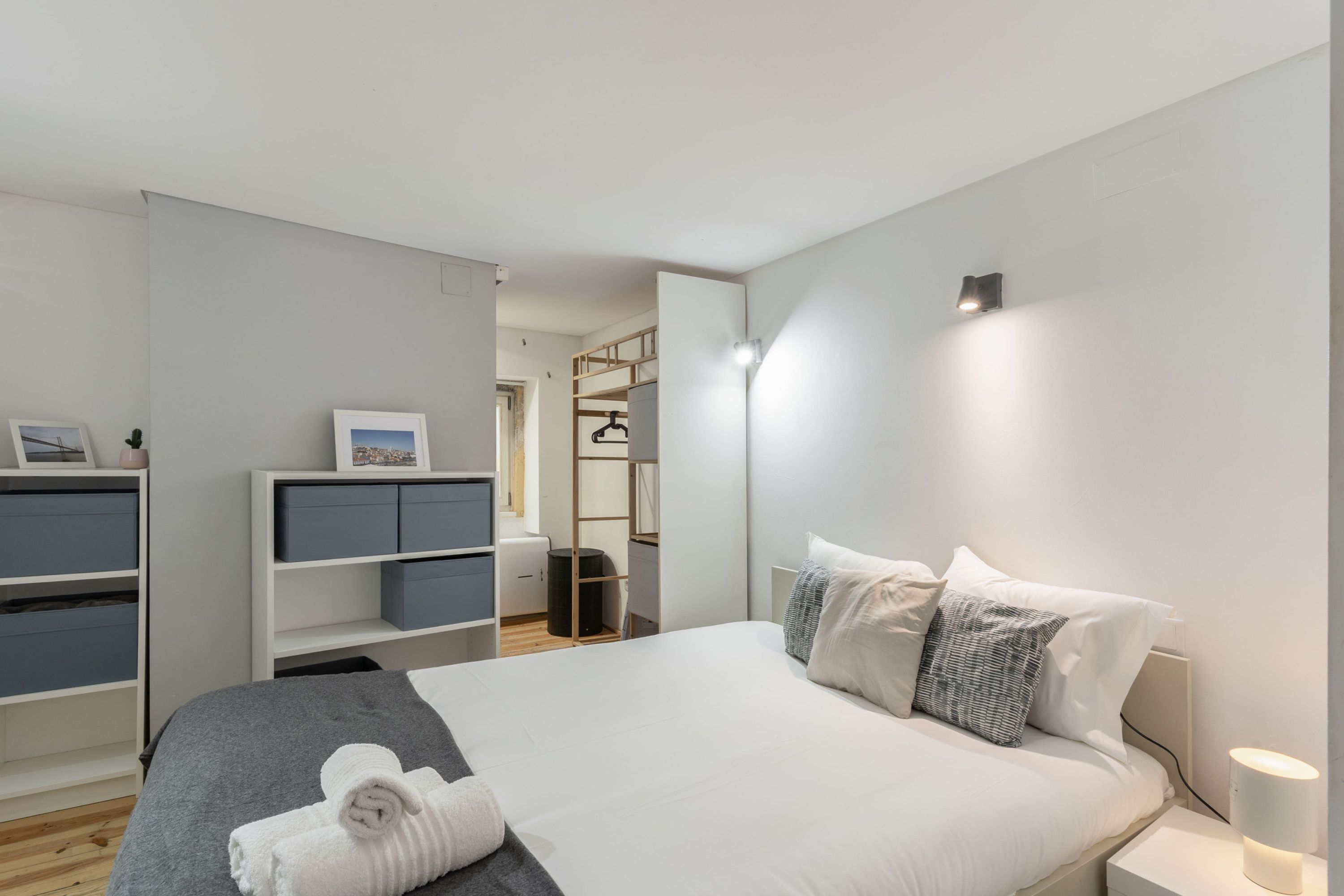 Een moderne slaapkamer met een bed, nachtkastjes, een garderobe en een inloopkast.
