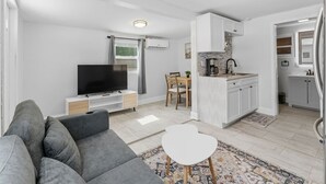Moderni huoneisto, jossa on olohuone, ruokailutila ja keittiö.
