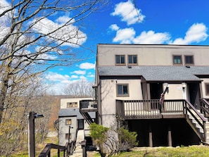 A multi-story building with a balcony, a staircase, and a sign indicating 'Welcome.' - Camelback Ski-in/Ski-out  Game Room & Pool (Tannersville)