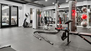 Et fitnessrum med træningsudstyr, et løbebånd og en loftsvift.