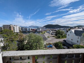 Un barrio residencial con edificios modernos, una ribera y una montaña al fondo.