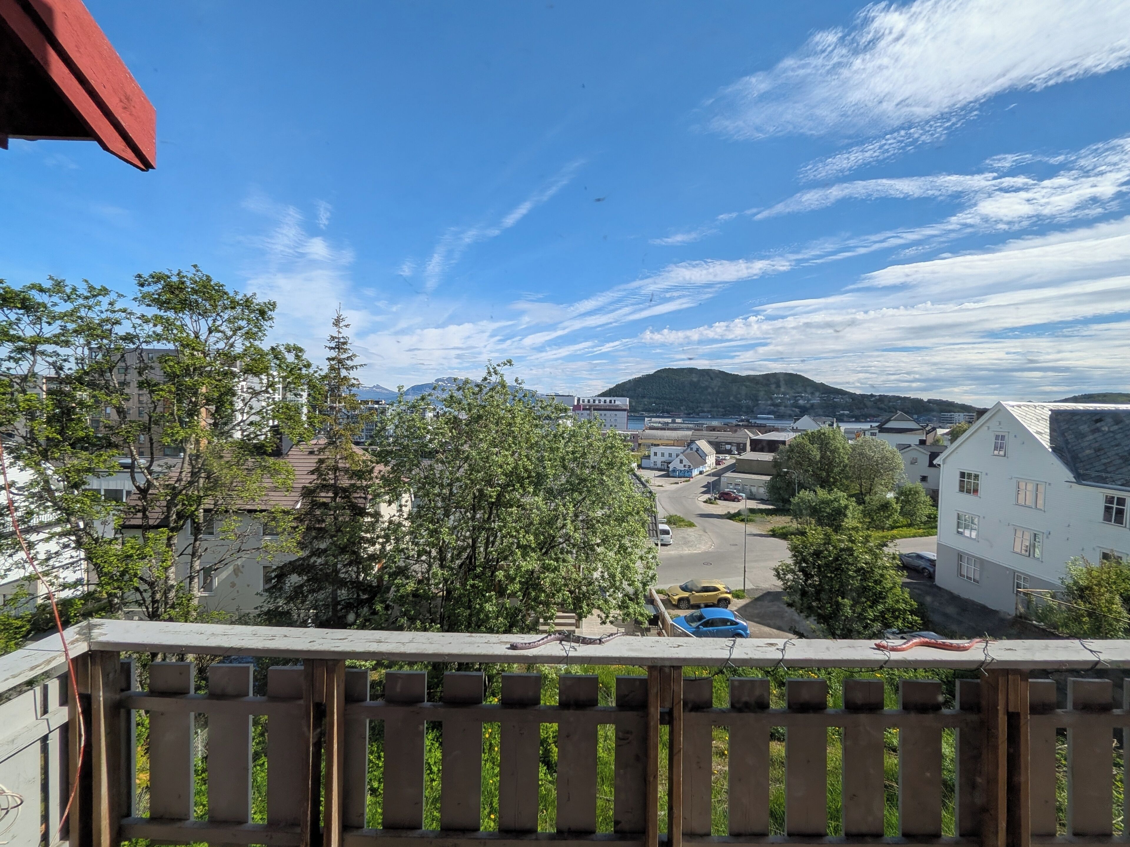 A residential area with houses, a road, and a mountain in the background.