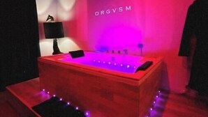 Una habitación con una cama, una lámpara de pared y un cartel con la palabra 'ORGVSM'.