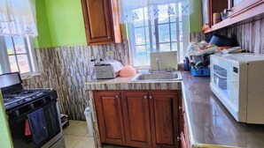 A kitchen with a stove, oven, sink, and cabinets.