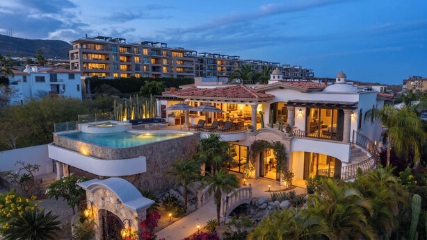Ein luxuriöses Resort mit Pool, Sitzgelegenheiten im Freien und Blick auf die umliegenden Gebäude.
