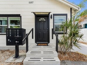 A building with a black front door, a mailbox, and a number '1157' above the door. - Clearwater Charm Unit D (Clearwater)