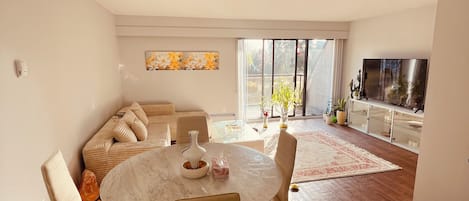 A modern living room with a round table, sofas, and a TV.
