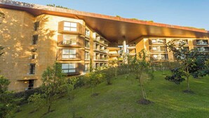 A multi-story building with balconies, a flat roof, and a grassy courtyard. - Fully Equipped Suite Near JMC Airport (Rionegro)