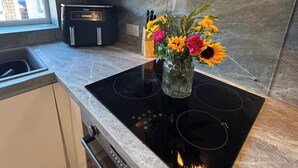 A modern kitchen with a built-in stove, a window, and a cabinet above the sink.