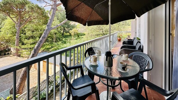 A balcony with a table, chairs, and an umbrella. - Caleta CostaBravaSi - Rest 650 m from the beach (Castell d'Aro)