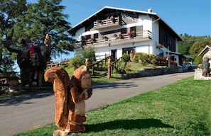A two-story building with a balcony, a sign reading 'Rustico,' and a statue of a bear.