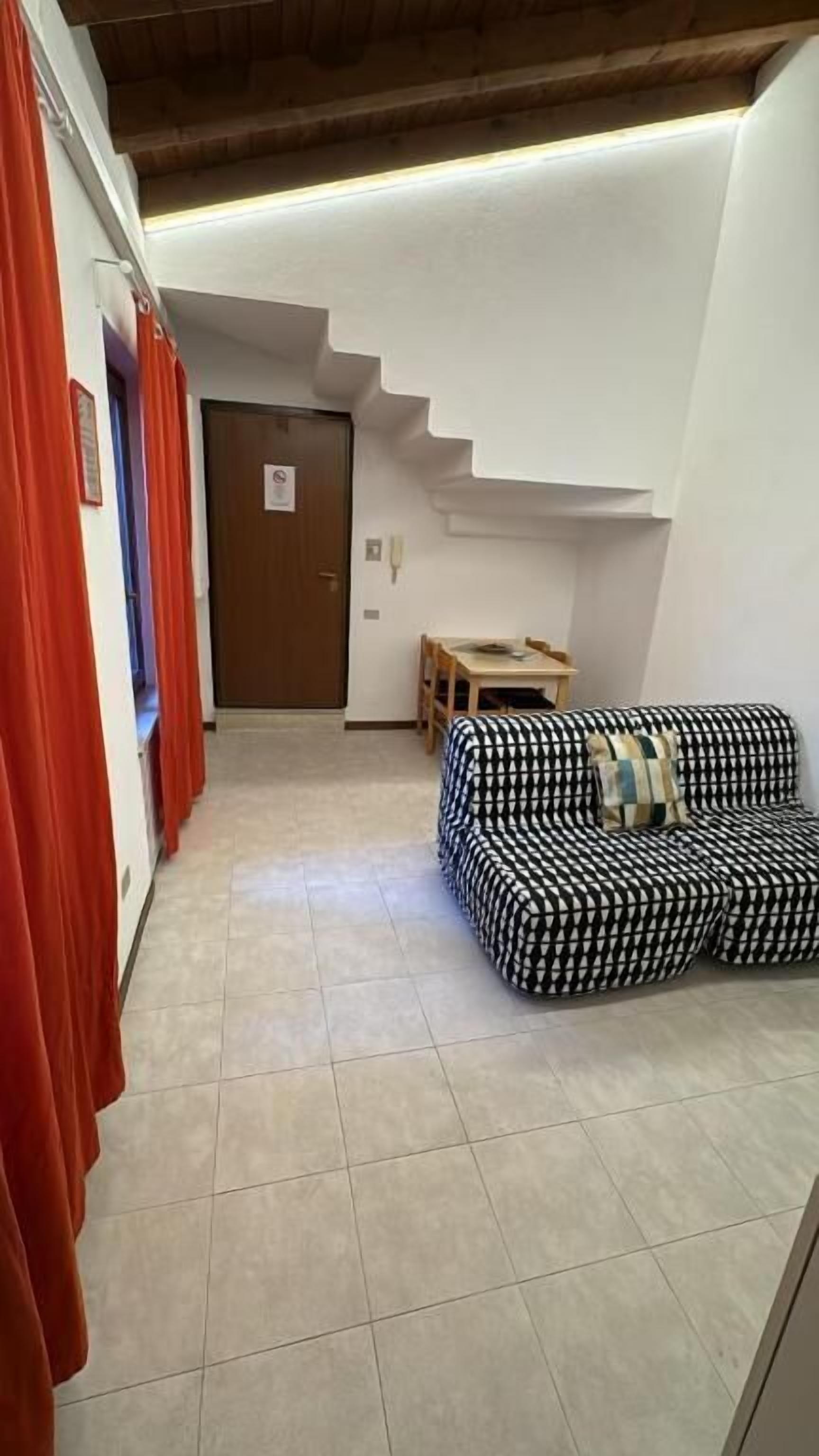 Ein Flur mit Treppe, Sofa und Tisch.