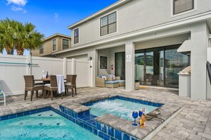 A pool area with a hot tub, outdoor seating, and a covered patio. - 6BR Stylish Reunion Villa • Pool • Near Disney (Reunion)