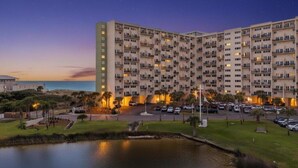 A multi-story hotel with a parking lot and a body of water in front. - Ocean Views, Pinnacle Port A-108 (Panama City Beach)