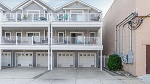 Ein zweistöckiges Gebäude mit Balkon, Garagen und Technikräumen.