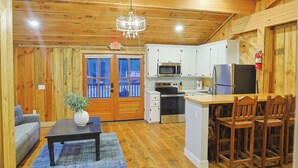 Un interior de madera con cocina, comedor y sofá.