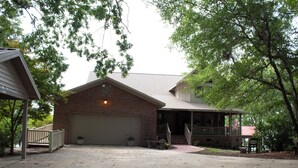 A two-story house with a garage, a covered porch, and a brick exterior.