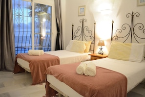 A hotel room with two beds, a balcony with a view, and a nightstand with a lamp. - Chalet by the Sea, with private parking, common swimming pools and tennis court (AN)