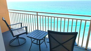 A balcony with two chairs and a table, overlooking a clear blue ocean. - New Listing Discount! 1804 W Splash Beach Resort-1BR+Bunks-Gulf Views (Panama City Beach)