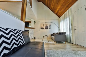 Ein modernes Wohnzimmer mit Sofa, einem kleinen Tisch und einer Treppe zu einer oberen Ebene.