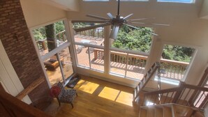 A high-ceiling room with large windows, a wooden staircase, and a ceiling fan. - Rarest of the rare.  Sky house. Best view in the tri-state (Wantage)