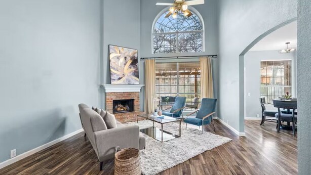 A spacious living room with a fireplace, a large window, and a dining area. - New Centrally Located North Richland Hills Home (North Richland Hills)